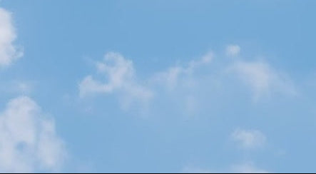 A bright blue sky with scattered white clouds.